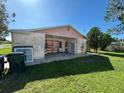 Open backyard with a covered patio area and shelving units at 8409 Trionfo Ave, North Port, FL 34287