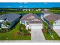 Beautiful aerial view of home with a two car garage, lovely landscaping and lake views at 10177 Crystal Isle Cir, Sarasota, FL 34241