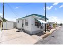 Well-maintained mobile home with a white exterior, teal awning, and convenient parking area at 10315 Cortez W Rd # 60-4, Bradenton, FL 34210