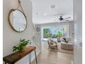 Bright living room with a view of the backyard pool through sliding glass doors and coastal-themed decor at 1738 Siesta Dr, Sarasota, FL 34239