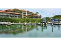 Picturesque waterfront featuring a marina with boat slips and luxury condominium in the background at 225 Sands Point Rd # 6201, Longboat Key, FL 34228
