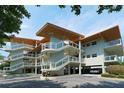 Modern condo exterior featuring glass railings, covered parking, and manicured landscaping at 225 Sands Point Rd # 7205, Longboat Key, FL 34228