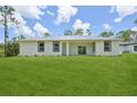 Spacious backyard with lush green lawn surrounding a modern single-story home at 2523 Hagerick Ln, North Port, FL 34288