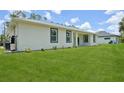 Lush green backyard with well-maintained lawn surrounding a modern, single-story home at 2523 Hagerick Ln, North Port, FL 34288