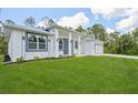 Modern new construction home featuring a well-maintained lawn and stylish architectural details at 2523 Hagerick Ln, North Port, FL 34288