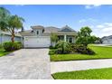 Charming single-Gathering home featuring a two-car garage, paver driveway, and lush landscaping at 2586 Wild Cherry Path, Sarasota, FL 34240
