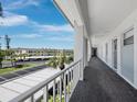 Exterior walkway with palm trees, leading to condo units with covered parking view at 4420 Exeter Dr # 303, Longboat Key, FL 34228
