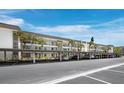 Exterior view of covered parking area with mature palm trees lining the condominium complex at 4420 Exeter Dr # 303, Longboat Key, FL 34228