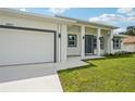 A close-up of a modern home with a two-car garage, walkway, and freshly landscaped yard at 4855 Dragon St, North Port, FL 34288