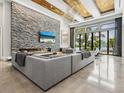 Spacious living room with a stone accent wall, fireplace, and picturesque water views at 4907 Topsail Dr, Nokomis, FL 34275