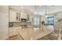 Well-lit kitchen with an island, pendant lighting and seamless access to the dining area at 5234 Napoli Run, Bradenton, FL 34211