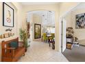 Bright entryway with tile floors, decorative bench, and seamless flow into the dining and living spaces at 6155 Aviary Ct, Bradenton, FL 34203