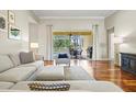 Sun-filled living room with hardwood floors, neutral furniture, and sliding doors to the backyard at 6216 Donnington Ct, Sarasota, FL 34238