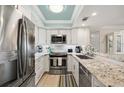 Modern kitchen featuring white cabinetry, granite countertops, and stainless steel appliances at 6415 Midnight Pass Rd # 502, Sarasota, FL 34242
