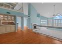 Open-concept living room with vaulted ceilings, fireplace, and hardwood floors offers a bright, inviting space at 65 Tidy Island Blvd, Bradenton, FL 34210