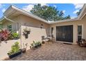 The brick-paved patio features neutral stucco walls with hanging plants and seating for outdoor enjoyment at 6916 W Country Club N Dr # 9B, Sarasota, FL 34243