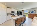 Modern kitchen with white cabinets, a center island, and seating with a water view at 7160 Amelia River Dr, Parrish, FL 34219
