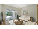Comfortable living room with sliding glass doors to screened in lanai at 8239 Cypress Hollow Dr, Sarasota, FL 34238