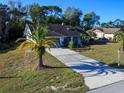 Single-story home with palm tree, well-maintained lawn and a paved driveway at 8260 Berkeley Manor Blvd, Spring Hill, FL 34606