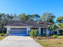 Single-story home with attached garage, mature landscaping and a paved driveway at 8260 Berkeley Manor Blvd, Spring Hill, FL 34606