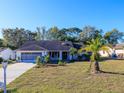 Charming single-story home with a well-maintained lawn, mature trees, and a two-car garage at 8260 Berkeley Manor Blvd, Spring Hill, FL 34606
