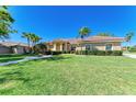 Charming single-story house with a well-manicured lawn, mature palm trees, and tidy shrubbery at 8315 Eagle Xing, Sarasota, FL 34241