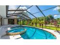 Inviting screened-in pool area with spa, perfect for relaxation and outdoor entertainment at 891 Faulkwood Ct, Sarasota, FL 34232