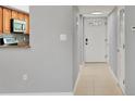 Entryway with tile flooring, a white front door, and a view into the kitchen through a cut-out at 924 La Costa Cir # 4, Sarasota, FL 34237
