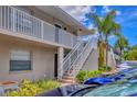 Condo exterior featuring stairs to the upper level, clean landscaping, and freshly painted white railings at 924 La Costa Cir # 4, Sarasota, FL 34237
