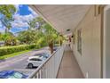 Exterior walkway featuring white railings, view of the parking area, and well-maintained landscaping at 924 La Costa Cir # 4, Sarasota, FL 34237