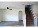 Living room featuring hardwood floors, a ceiling fan, and a staircase at 10019 Geese Trail Cir, Sun City Center, FL 33573