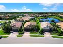 Aerial view of home featuring mature trees and lush landscaping in a serene neighborhood with a tranquil lake at 11221 Sandhill Preserve Dr, Sarasota, FL 34238