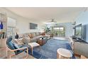 Living room with comfortable seating, blue accent rug, and view of the screened lanai at 1319 Perico Point Cir, Bradenton, FL 34209
