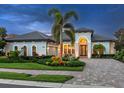 Beautiful single-Gathering home featuring a paver driveway, arched entryway, and well-manicured lawn at 16628 Berwick Ter, Lakewood Ranch, FL 34202