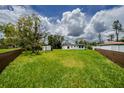 Large backyard with lush green grass, enclosed by fences, providing ample space for outdoor activities and privacy at 211 22Nd Street Ne Ct, Bradenton, FL 34208