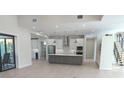 Open kitchen features stainless appliances, pendant lights, and a large central island, perfect for entertaining at 2110 Michele Dr, Sarasota, FL 34231