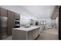Contemporary kitchen featuring stainless steel appliances and quartz countertops, opening to the living area at 2221 Wood St, Sarasota, FL 34237