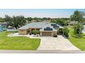 Inviting single Gathering home featuring a well-manicured lawn, solar panels, and a spacious driveway at 23136 Langdon Ave, Port Charlotte, FL 33954