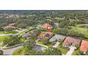 Aerial view of a single-story home with solar panels and a tile roof in a lush neighborhood at 2518 Dick Wilson Dr, Sarasota, FL 34240