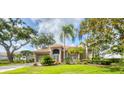 Beautifully landscaped single-story home with mature trees, tile roof and two-car garage at 2518 Dick Wilson Dr, Sarasota, FL 34240