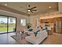 Open-concept living room and kitchen with sleek countertops, stainless steel appliances, and expansive windows at 350 Bucknell Rd, Venice, FL 34293