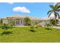 Inviting single-story home boasting a well-manicured lawn, mature palm trees, and covered entry at 3615 Tripoli Blvd, Punta Gorda, FL 33950