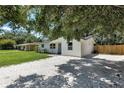 Side angle of the home with fresh gravel driveway and a new fence along the back of the property at 4041 Linwood St, Sarasota, FL 34232