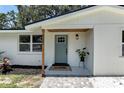 Close up of the home's front entry featuring a new door, porch tile, wood columns, and updated lighting at 4041 Linwood St, Sarasota, FL 34232