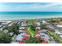 Aerial view of a beachfront community with red-roofed homes, mature trees, and a refreshing blue pool at 500 Park S Blvd # 97, Venice, FL 34285