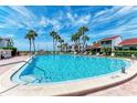 Inviting outdoor pool surrounded by palm trees, lounge chairs and community buildings on a sunny day at 500 Park S Blvd # 97, Venice, FL 34285