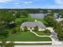 A spacious single-story home with a landscaped front yard and lake views surrounded by mature trees at 5012 Cherry Laurel Way, Sarasota, FL 34241