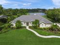 A landscaped single-story home with a well-maintained lawn and picturesque views of the adjacent lake at 5012 Cherry Laurel Way, Sarasota, FL 34241