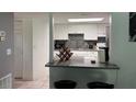 Bright kitchen featuring white cabinets, stainless steel sink, and breakfast bar with black stools at 5026 Water Oak Dr # 114, Bradenton, FL 34207