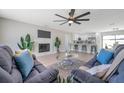 Bright living room features modern ceiling fan, fire place, and open floor plan to the kitchen at 5032 Barcelona Ave, Sarasota, FL 34235